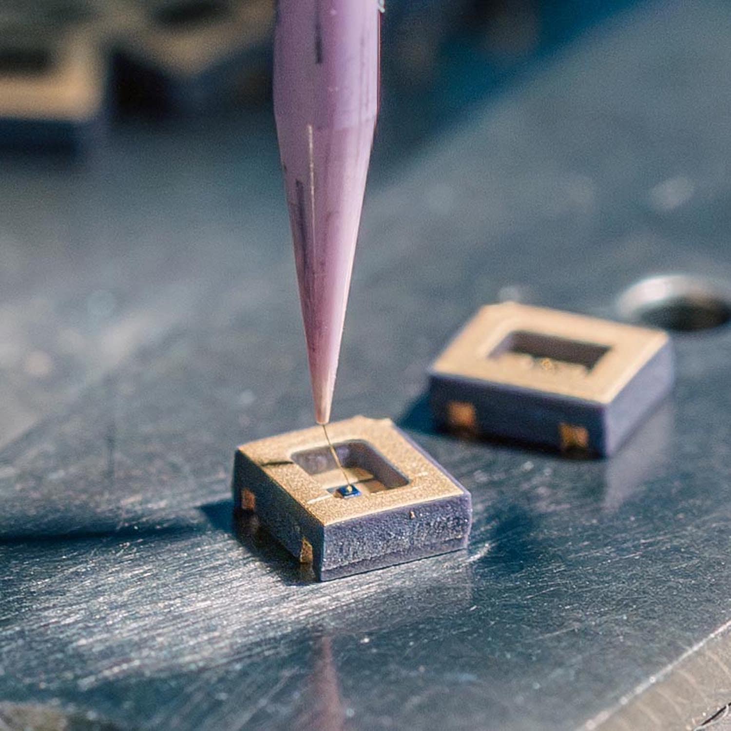 Bonding tool feeding a fine wire into a windowed ceramic package