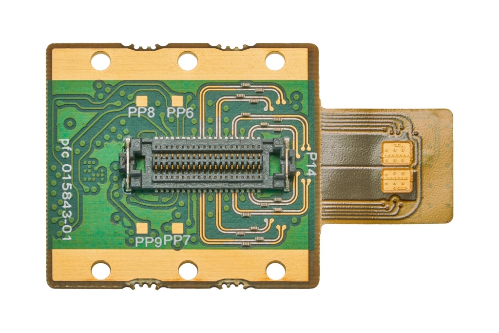 Custom printed circuit board with gold traces and a fine-pitch connector, studio macro photograph